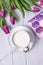 White cup with coffee cappuccino, book and purple tulips on a white background. Free space