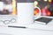 White cup of coffee, diary, glasses and pen on a wooden table