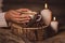 White cup with coffee in the hands of the girl, candles, fur and coffee beans