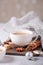 White cup with coffee and marshmallow, sweater, cinnamon. Cozy christmas composition. Hygge concept Soft focus