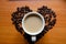 White cup of coffee in the middle of heart shaped coffee beans