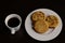 A white cup of coffee next to a plate with three arepas typical Colombian food