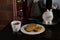 A white cup of coffee next to a plate with three on a table with Christmas decorations arepas typical Colombian food