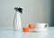 White cup of coffee, orange macaroons, vase with a sprig of dried berries on white background, close up