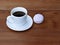 White cup of coffee and pink zefir on the wooden background.