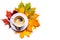 White cup with coffee on a saucer on a background of autumn leaves.