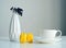 White cup of coffee, yellow macaroons, vase with a sprig of dried berries on white background, close up