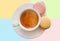 White cup of espresso coffee with colourful french macarons top view on colorful background, Good morning or have a nice day