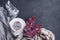 White cup with flowers on a saucer, a bouquet of lilac flowers and a blue drape striped scarf on a dark background