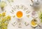 White cup with frame of tea bags and text herbal tea on white table background, top view. Herbal tea set with teapot , honey and