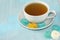 White cup with green tea on a saucer with multi-colored marmalade sweets.Sugar sweet Christmas sweets. Different gelatinous sweet