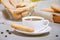 A white cup of hot aromatic coffee with steam and traditional Traditional italian savoiardi biscuits or ladyfingers cookie