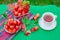 A white cup of hot tea with apples of paradise in the morning in the garden, with a blurred natural background