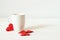 White cup and origami red hearts. Mockup empty mug on wooden white background.