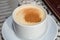 White cup of salep milky hot drink of Turkey with cinnamon powder and sticks healthy spice