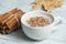 White cup of salep milky hot drink of Turkey with cinnamon powder and sticks healthy spice and autumn winter leaf on white rustic