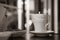 A white cup of tea is placed on a black and white table. contemplative moment concept