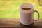 A white cup of tea on the railing of the Wooden terrace. Morning concept. Close-up