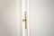 White cupboard doors with Golden key in keyhole, luxury antique design close-up wooden vintage doors