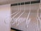 White Curvy Cloth Hangers and Towel Inside the Wardrobe