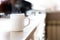 White cylinder cup on kitchen table with real natural daylight, mock-up ready coffee mug
