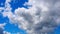 White and dark clouds fly rapidly across the blue sky. Time lapse atmosphere. Weather changes. Movement of clouds across