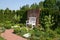 A white decorative bench by a brick wall surrounded by a beautiful romantic garden