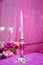 White decorative candles pink backgrounds . Beautiful candle on pink background . Candle in candlestick burning . Retro Candelabra