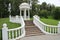 White decorative gazebo with a fence and a ladder