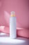 White deodorant body spray or shower foam bottle on pink background with paper decor mockup template, container with no brand