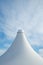 White detail of big top tent against a blue an cloudy sky