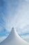 White detail of big top tent against a blue an cloudy sky