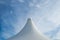 White detail of big top tent against a blue an cloudy sky