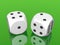 White dices on green background
