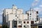 White dilapidated apartment buildings in old part of town with multiple satellite dishes and chimneys in various sizes