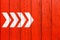 White directional arrow signs pointing direction painted on a red wood wall signboard texture background