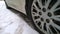 White Dirty Car wheel on road. Messy, Mud, salt, chemicals in winter. Tire. Ecology problem in city. Protection and wash vehicle