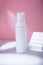 White dispenser mockup on pink backdrop in harsh light, no brand template. Cleansing moisturizing facial foam container, concrete