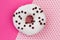 White donut on pink patterned background.