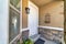 White door and window with blinds at home facade with concrete and stone wall