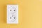 White double socket isolated on yellow background. Electric lighting