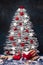 White driftwood christmas tree with star and snowflakes decorations on dark blue wooden background