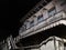 White dwelling house with balcony and closed blue shutters at night