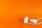 White earbuds on orange colorful background