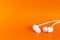 White earbuds on orange colorful background