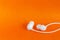 White earbuds on orange colorful background