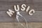 White earbuds and word \'music\' on wooden table