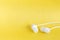 White earbuds on yellow pastel background