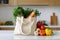 White eco friendly shopping bag with fresh vegetables. Linen tote shopper bag on modern kitchen table