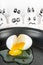 White egg broken in skillet with eggs with faces scared.